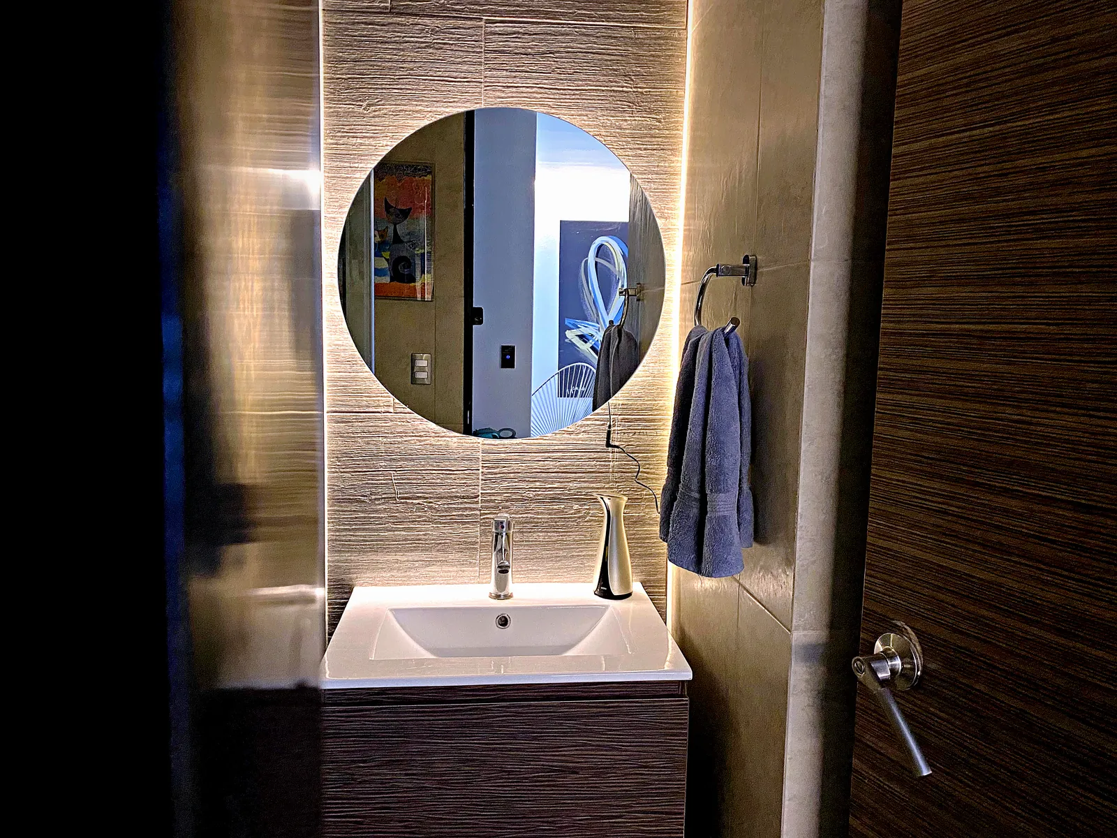 Espejo redondo con luz LED posterior sobre lavabo